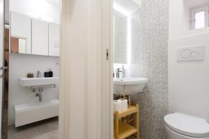 a white bathroom with a sink and a toilet at Elegantis Trastevere Modern Apartment - Comfort in Rome Most Charming District in Rome +25 photos