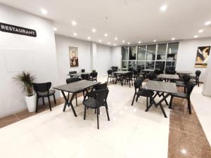 a restaurant with tables and chairs in a room at Perlina Hotel Erbil in Erbil