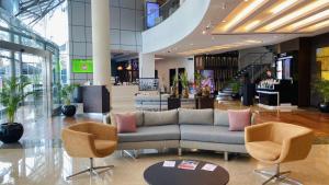 a lobby with a couch and chairs in a mall at Holiday Inn Abu Dhabi by IHG in Abu Dhabi