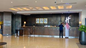 a man and a woman standing in a lobby at Holiday Inn Abu Dhabi by IHG in Abu Dhabi