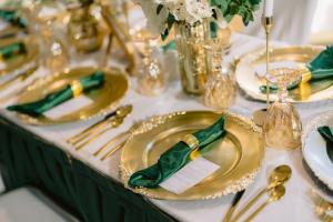 a table with gold plates with napkins on it at Holiday Inn Abu Dhabi by IHG in Abu Dhabi
