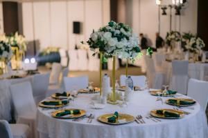 a white table with plates and flowers on it at Holiday Inn Abu Dhabi by IHG in Abu Dhabi