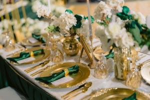 a table with gold plates and vases with flowers at Holiday Inn Abu Dhabi by IHG in Abu Dhabi