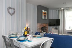 a dining room table with plates and wine bottles on it at Cosy seaside cottage in Criccieth