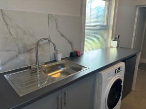 a kitchen with a sink and a washing machine at Chalkwell Aparthotel Short & Long Stays Welcome, Leisure , Relocation , Business Stays , Contractors in Kent +63 photos