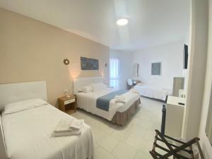 ein Hotelzimmer mit zwei Betten und einem Stuhl in der Unterkunft Hotel Lorenza B&B e Mini Suite in Cavoli
