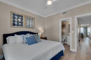 a bedroom with a large bed with blue and white pillows at Bikini Bottom by Gulf Coast Getaways in Navarre
