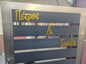 a sign for a tesos and lothoth store at petros house in Sarti