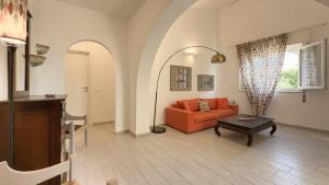 a living room with an orange couch and a table at Villa Leandra in Fontane Bianche