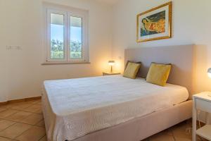 a bedroom with a large white bed with a window at Cicale relaxing home - aria condizionata, parcheggio, giardino in Termoli