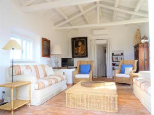 una sala de estar con sofás y sillas blancos en La Casa del Faro, en Porto Ercole
