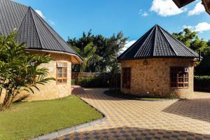 a small brick building with a black roof at Shoki Shoki Lodge Arusha in Arusha