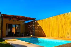 a swimming pool in front of a wooden fence at Hermosa Casa, Chacras de Coria-Pileta-Parrilla-AA in Ciudad Lujan de Cuyo