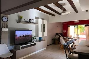 a living room with a flat screen tv on a wall at Hermosa Casa, Chacras de Coria-Pileta-Parrilla-AA in Ciudad Lujan de Cuyo