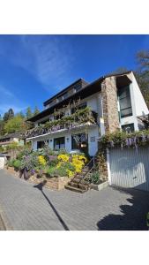 a house with a bunch of flowers in front of it at Ferienwohnung am Meulenwald in Föhren