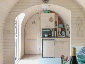 an archway in a kitchen with a sink and a refrigerator at Iglucraft Tiny Haus im Naheland I Grill I Wasserspielpatz I W-LAN in Heddesheim
