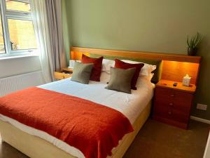 a bedroom with a bed with a red and white comforter at Vintage Vibes in Weston-super-Mare