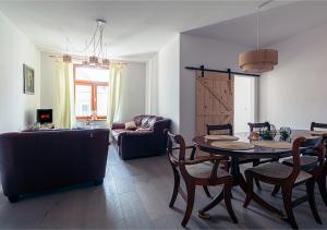 un soggiorno con tavolo, sedie e divano di Apartamenty Laguna CudNajem a Tolkmicko