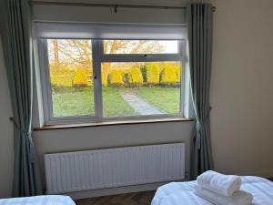 a bedroom with a window with towels on a bed at Hillside Home in Donegal +16 photos