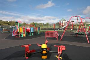 a park with a playground with slides and swings at Hillside Home in Donegal