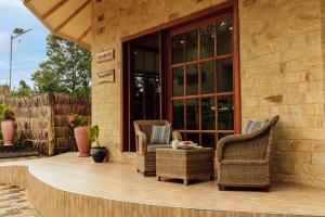 a patio with wicker chairs and a table at Shoki Shoki Lodge Arusha in Arusha +78 photos
