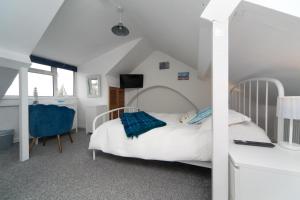 a bedroom with a bed and a desk and a chair at 6 Afallon, Beachside holiday house in Criccieth
