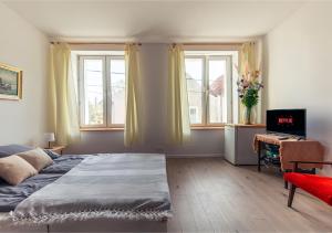 una camera da letto con un letto, una scrivania e finestre di Apartamenty Laguna CudNajem a Tolkmicko