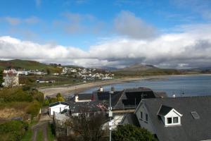 a town with a beach and a body of water at 6 Afallon, Beachside holiday house in Criccieth