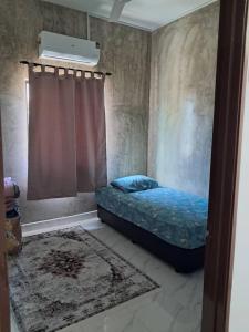 En eller flere senge i et værelse på Anggun Homestay