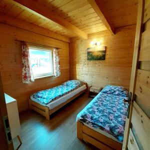 a bedroom with two beds in a wooden cabin at Domki na kamieńcu 47c in Ustrzyki Dolne