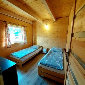 a room with two beds in a wooden cabin at Domki na kamieńcu 47c in Ustrzyki Dolne +9 photos