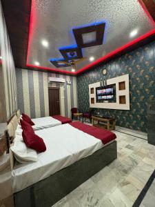 a bedroom with a large bed with red pillows at Captain Guesthouse in Mathura