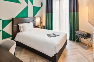 a hotel room with a large bed and a television at Mercure Napoli Centro Angioino in Naples