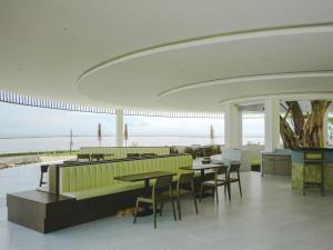 Pulau Tidung-besarにあるNirva Ocean Houseの海とテーブルと椅子が備わるレストラン