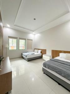 dwa łóżka w dużym pokoju z białym w obiekcie De Lavender Villa 3 w mieście Citaringgul 1