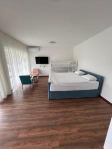 コニツにあるApartmani SEEBLICKのベッド、机、テレビのある寝室