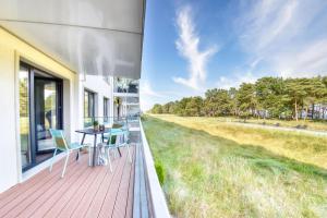 een terras met een tafel en stoelen op een huis bij Ferienwohnung Ostseeloft 5 im Haus Prora Düne 7 in Binz
