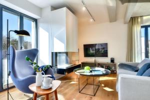 een woonkamer met een bank en een tafel bij Ferienwohnung Ostseeloft 5 im Haus Prora Düne 7 in Binz