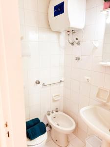 a white bathroom with a toilet and a sink at Costa House in Cefalù +32 photos