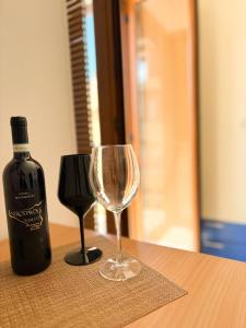 a bottle of wine and a wine glass on a table at Costa House in Cefalù