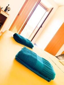 two pillows on a bed in a room with a window at Costa House in Cefalù