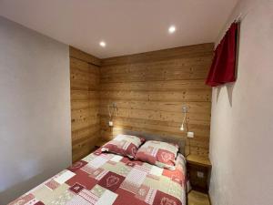 a bedroom with a bed with a wooden wall at Appartement 6 pers, proche pistes et commerces, Crest-Voland - FR-1-733-8 in Crest-Voland