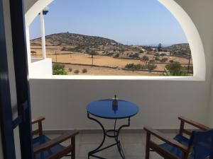 a table and chairs in a room with a window at Amalthea Schinousa in Schinoussa