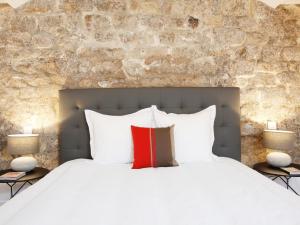 1 dormitorio con cama blanca y almohada roja en Charming apartment in heart of Paris, en París