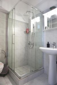 a bathroom with a glass shower and a sink at Ionian Blue Studio in Preveza +26 photos