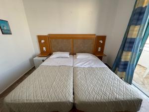 two twin beds in a small bedroom with a window at Arant in Mastihari