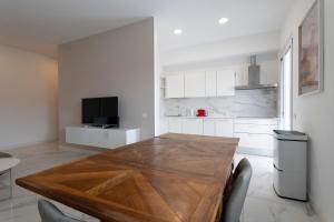 a kitchen with a wooden table in a room at GuestHost - Lovely Apartment X4 in Central Rimini in Rimini