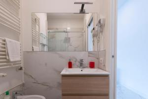 a white bathroom with a sink and a mirror at GuestHost - Lovely Apartment X4 in Central Rimini in Rimini +24 photos
