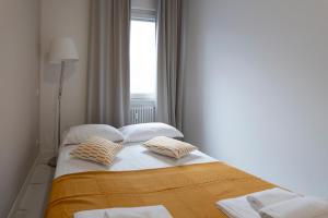 a bedroom with a bed with two pillows and a window at GuestHost - Lovely Apartment X4 in Central Rimini in Rimini