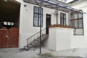 a white house with a staircase and windows at BLISS HOUSE Primariei in Oradea